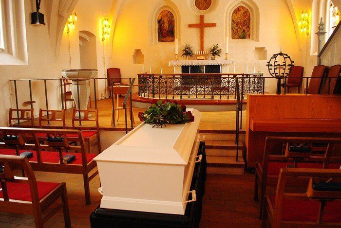 En kiste står klar til bisættelsen/begravelsen i kirken